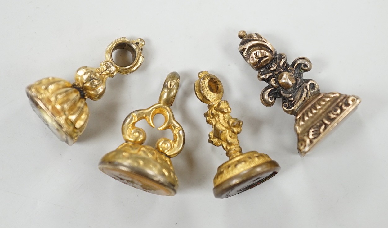 A 19th century yellow metal overlaid and amethyst set fob seal, the matrix carved with a phoenix, 20mm, together with four 19th century gold plated and chalcedony or citrine set fob seals.
